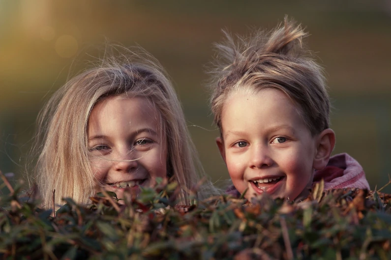 8 year olds cheakily peaking over hedge